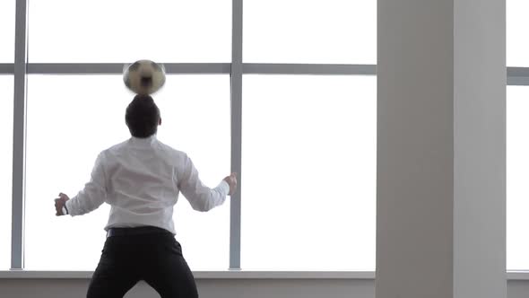 Businessman Joggling the Football