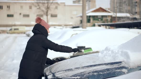 Sweep Snow From Automobile With Brushes In Winter. Scraping Ice. Scratching Ice From Car Window. alt