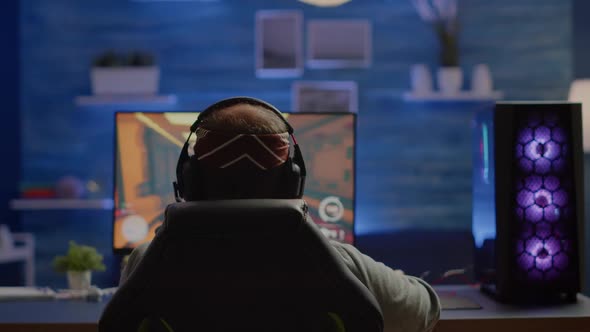 Back Shot of Happy Gamer Winning First Person Shooter Video Game alt