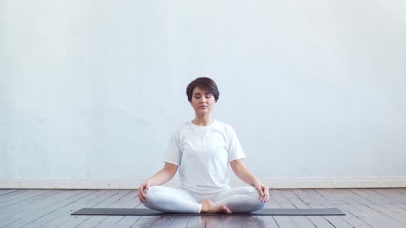 Young and fit woman practicing yoga indoor in the class. alt