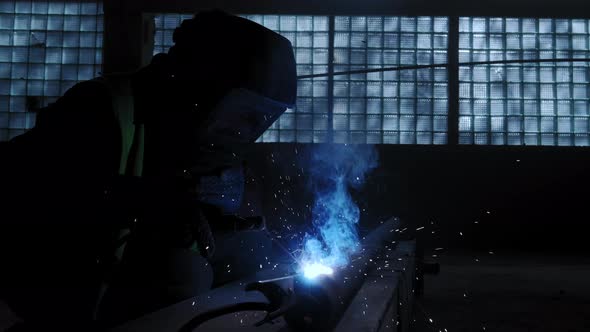 Close Up View of Factory Worker Welds Metal Using a Welding Machine alt