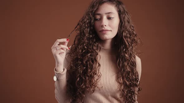 Studio portrait of young woman with long curly hair