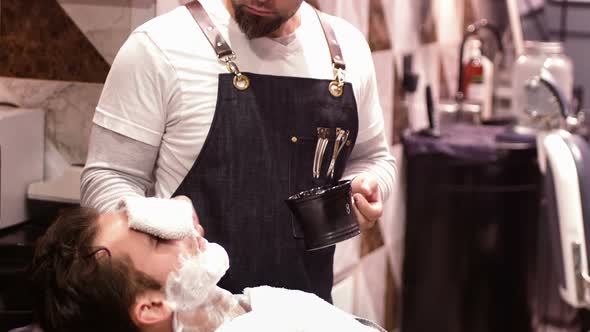 Man getting his beard shaved with shaving brush alt