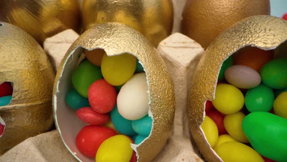 Golden Decorative Easter Eggs Filled with Colorful Candies on Wooden Table Close Up