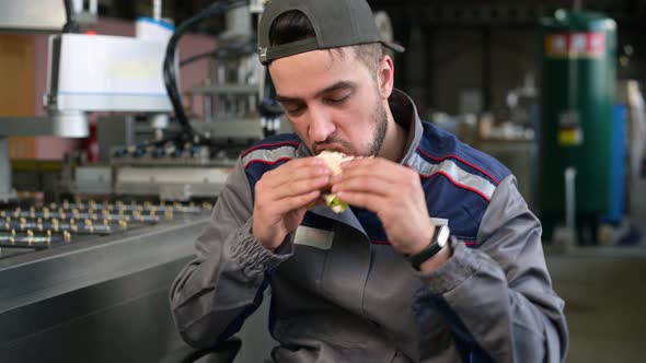 A young man takes food at workplace during work hours or during his lunch break alt