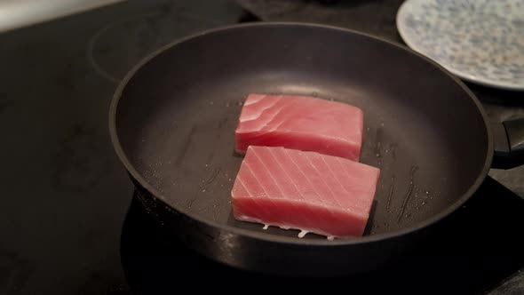 Chef Turns Two Tuna Steaks with Tongs To Fry All Sides Cooking Dinner at Home