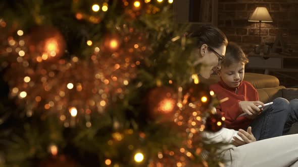 Boy and his mother using a digital tablet together on Christmas