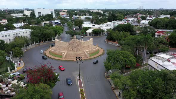 Slow aerial ascent showing traffic roundabout with Monument a la Patria, Homeland Monument on the Pa alt