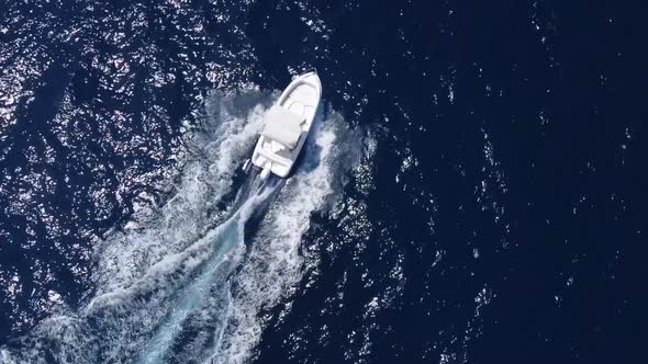 Aerial circling top down shot of speedboat driving on Sea in the near of Sicily,Italy during sunny d alt