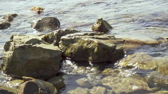 Small Waves Roll on Rocks on the Shore