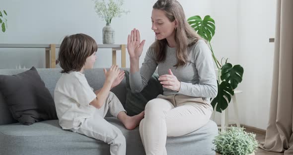 Female Parent Playing with Male Kid Clapping Hands at Home alt