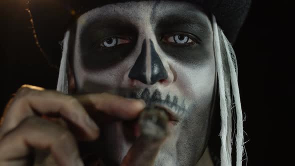 Close-up Shot of Sinister Man Face with Halloween Skeleton Makeup Smoking Cigar, Making Faces alt