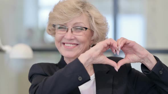 Portrait of Old Businesswoman Showing Heart Sign By Hand alt