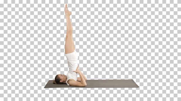 Woman practicing yoga standing in salamba sarvangasana alt