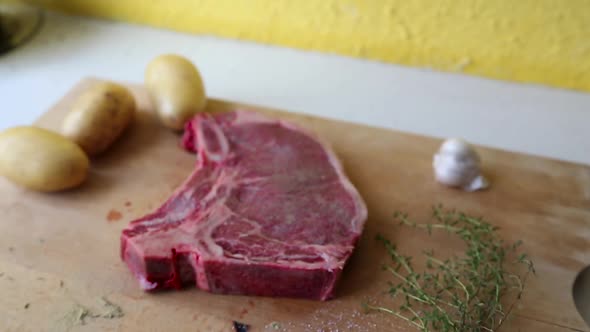 Camera Tilt and focus in over steak on wooden cutting board with garnish alt