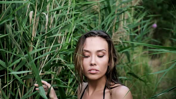 Sexy Young Slender Asian Girl in Bikini Makes Her Way Through Thickets of Reeds