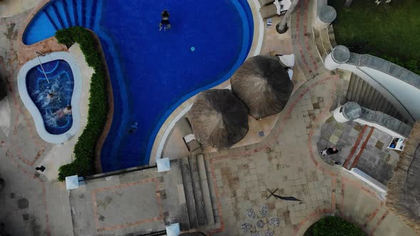 Aerial Drone View of Swimming Pool with Beach Umbrellas Beds with Hotel at Cancun Mexico alt
