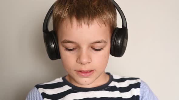 Teenage Boy Texting Using Smartphone Listening To Music Wearing Headphones