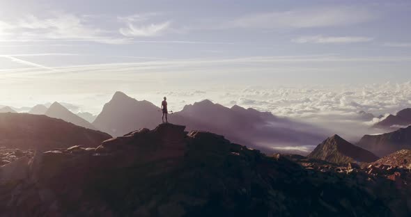 Aerial Trail Runner Man Standing on Mountain Top Peak Goal Looking Horizon View alt