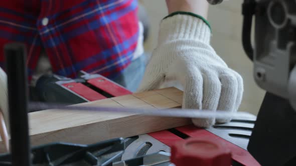Close-up of carpenter prepare wood for cutting wooden plank with a circular electric saw