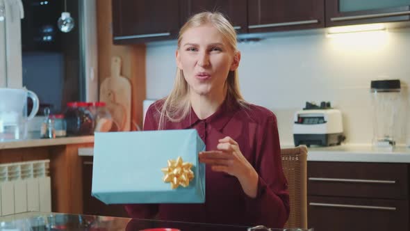 Blonde Woman Promoting Special Gifts for the Clients to the Camera