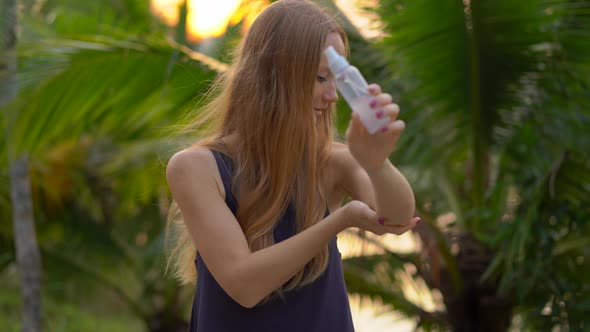 Closeup Shot of a Beautiful Young Woman Applying an Antimosquito Repellent Spray on Her Skin. A alt