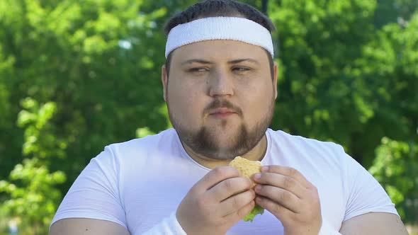Fat Man Eating Burger After Workout, Addicted to Junk Food, Lack of Willpower alt