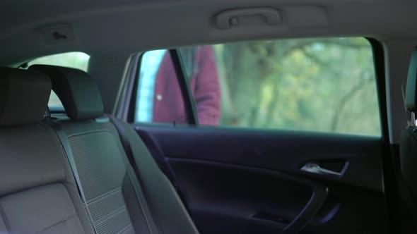 Woman in Protective Medical Mask Entering Taxi Car Sitting on Passenger Seat