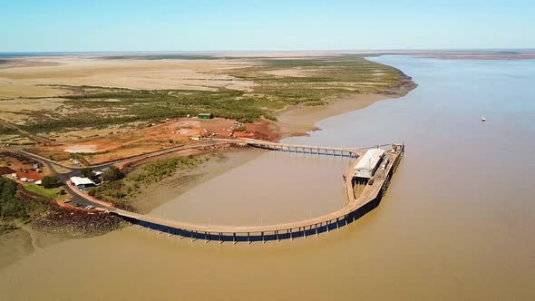 Circling aerial shot showing Derby port/jetty then revealing Derby township in the background. alt