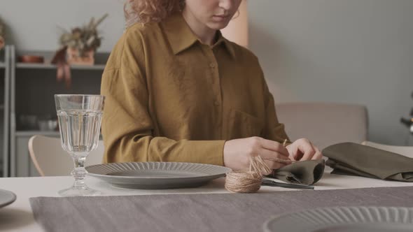 Tying Napkin with Twine at Table alt