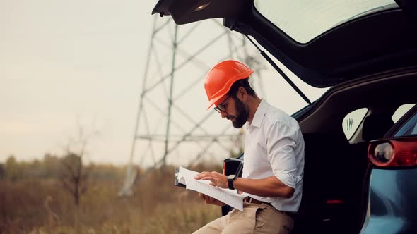 Engineer On Electricity Transmission Power Lines Wire.Builder Contractor Specialist Read Blueprints alt