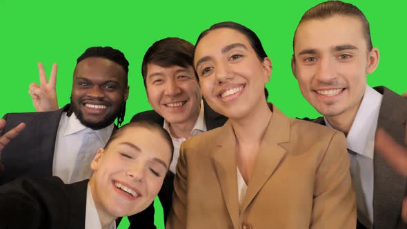 Young Colleagues Make Selfies and Smile on a Green Screen Chroma Key alt