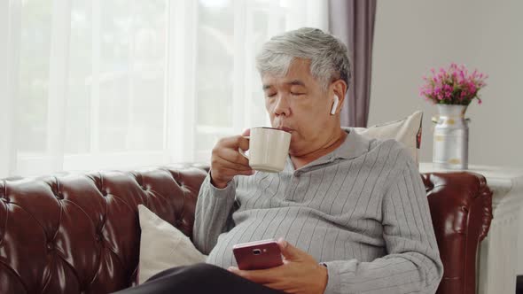 Senior man use wireless earphone listening music and talking telephone alt