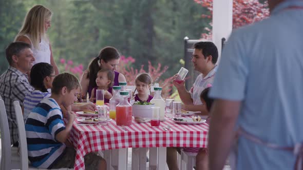 Group of people eating and enjoying a backyard barbeque