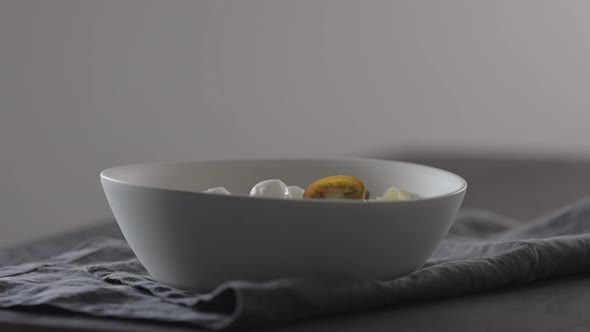 Slow Motion Put Kumato Tomatoes on Fettuccine in White Bowl on Linen Cloth alt