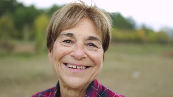 Happy Senior Woman Smiling on Camera Outdoor in the Woods  Real Elderly People Lifestyle alt