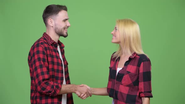 Young Happy Couple Shaking Hands Together