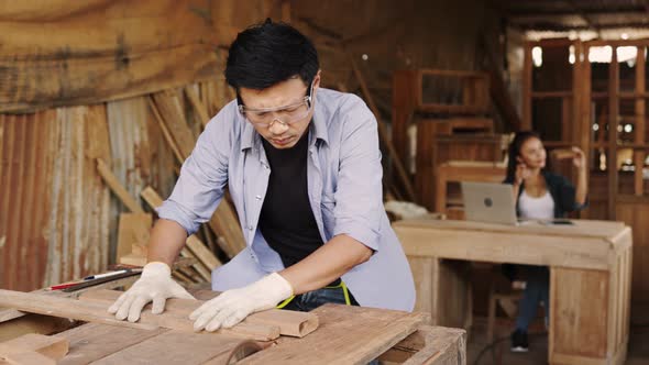 Two asian carpenters in a construction workshop. business man and woman working together alt