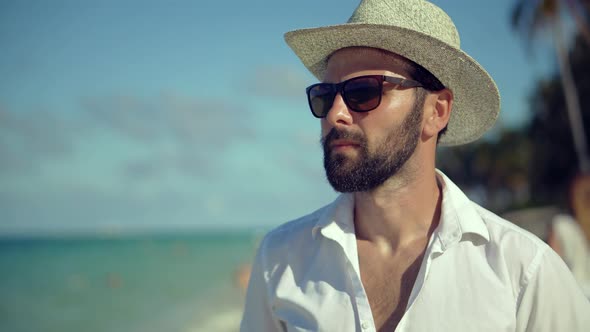 Man Walking On Tropical Beach. Guy Relaxing On Caribbean Sea Beach. Tanned Man In Hat. alt