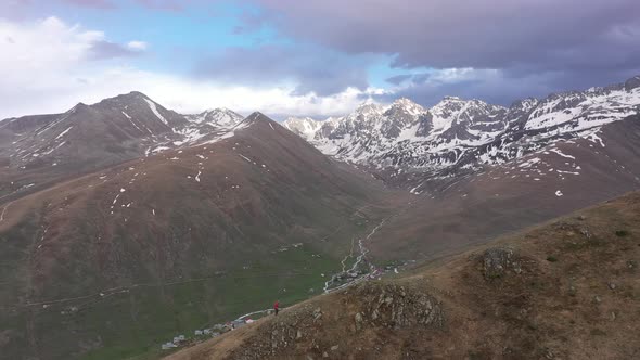 Aerial view of man walking on summit with drone