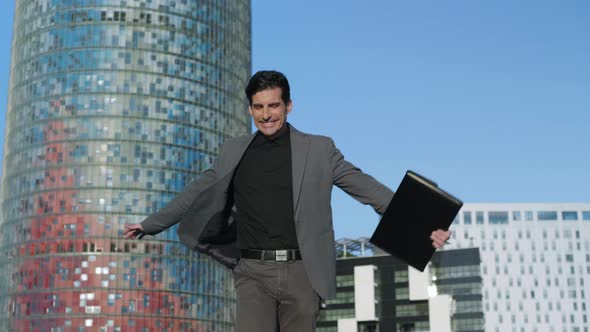 Joyful Businessman Walking on Street. Entrepreneur Jumping in Air Outdoors alt