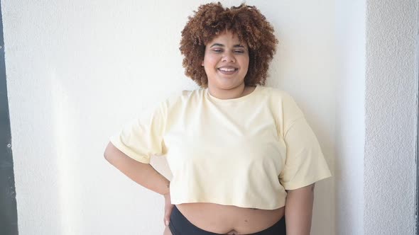 Beautiful Happy Curvy Plus Size African Black Woman Afro Hair Posing in Beige Tshirt and Black