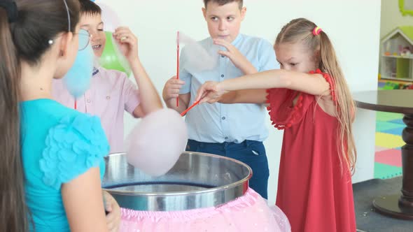 Children Eat Cotton Candies Near Machine at Birthday Party alt