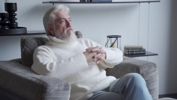 A Manly, Confident Old Man Is Sitting on a Chair. A Man Sits with a Thoughtful Look alt