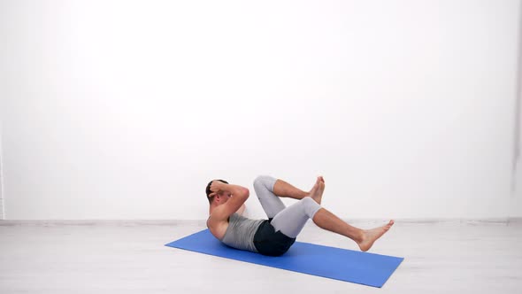 Muscular Sportsman Doing Bicycle Exercise on Fitness Mat Crunching alt