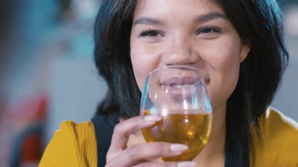 Young Latin American woman drinking beer with mate