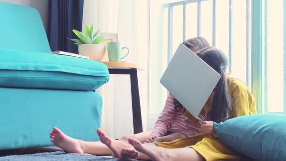 two asian female sibling sit exited watch movie online together alt