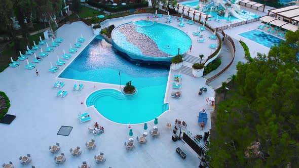 Flight Over the Beach with Umbrellas Towards the Pool in a Luxury Hotel alt