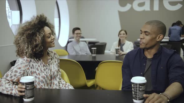 Woman using digital tablet and discussing with man in office cafe