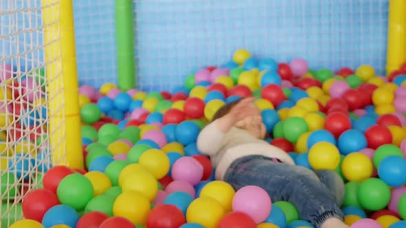 Child Plays in Play Center Kindergarten Pool with Balls Happy and Joyful Funny